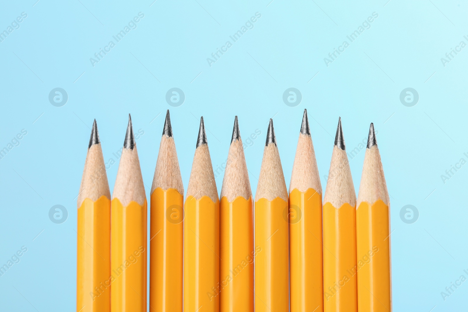 Photo of Many sharp graphite pencils on turquoise background, space for text. Macro view