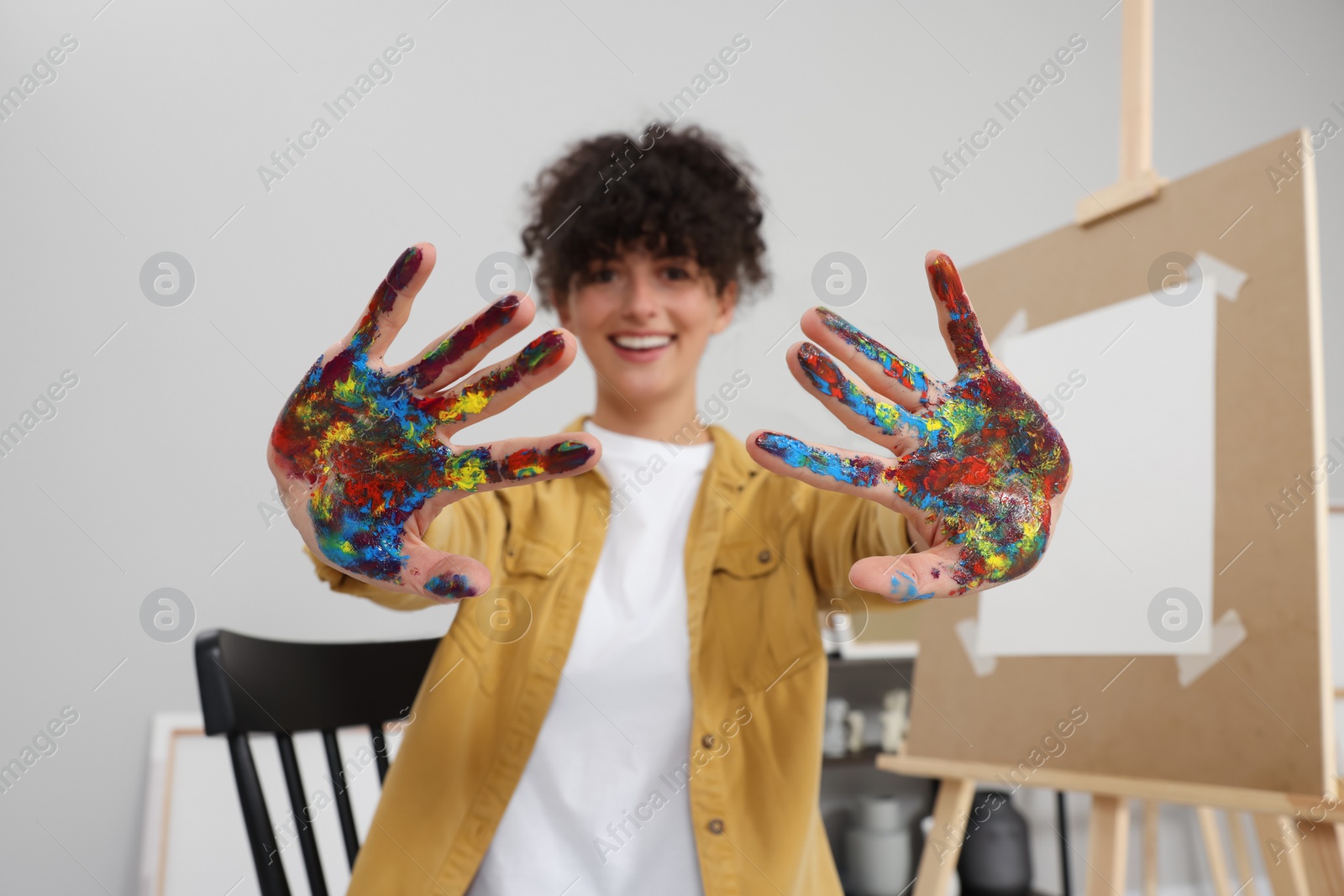 Photo of Young woman with painted palms indoors, selective focus