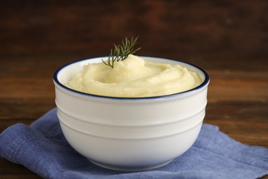 Photo of Freshly cooked homemade mashed potatoes with napkin on wooden table, closeup