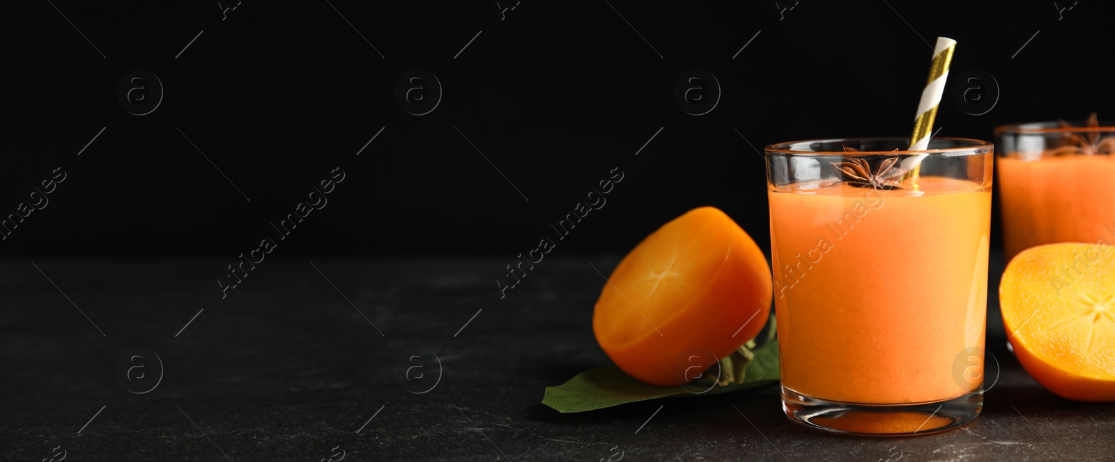 Image of Tasty persimmon smoothie with anise and fresh fruits on black table, space for text. Banner design