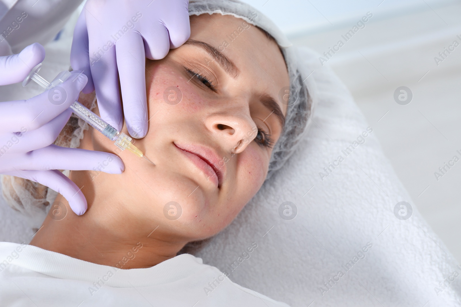 Photo of Woman undergoing face biorevitalization procedure in salon, closeup. Cosmetic treatment