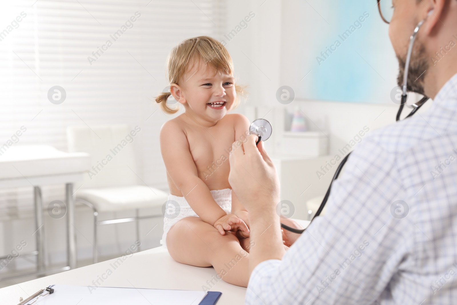 Photo of Pediatrician examining baby with stethoscope in clinic