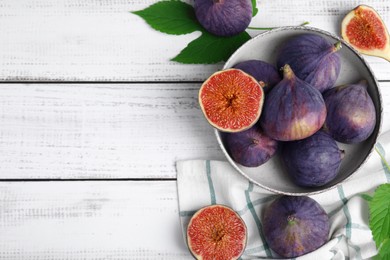 Photo of Fresh ripe purple figs on white wooden table, flat lay. Space for text
