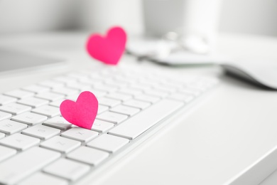 Photo of Keyboard with pink hearts on white table, closeup. Valentine's day celebration