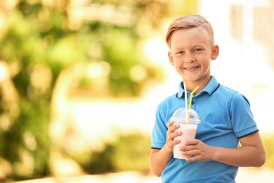 Photo of Little boy with cup of milk shake outdoors