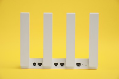 One modern Wi-Fi router on yellow background