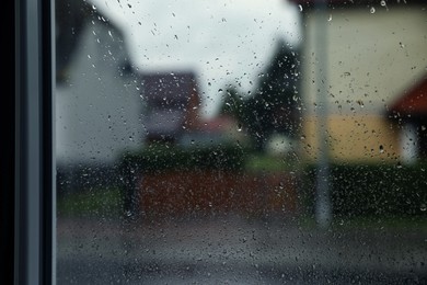 Photo of Window glass with water drops, closeup. Rainy weather