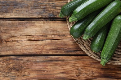 Photo of Raw ripe zucchinis on wooden table, top view. Space for text