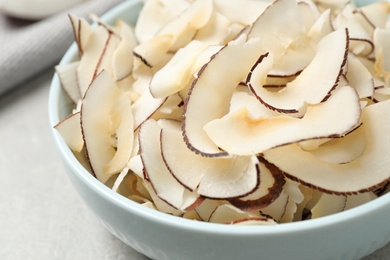 Photo of Fresh delicious coconut chips in bowl, closeup