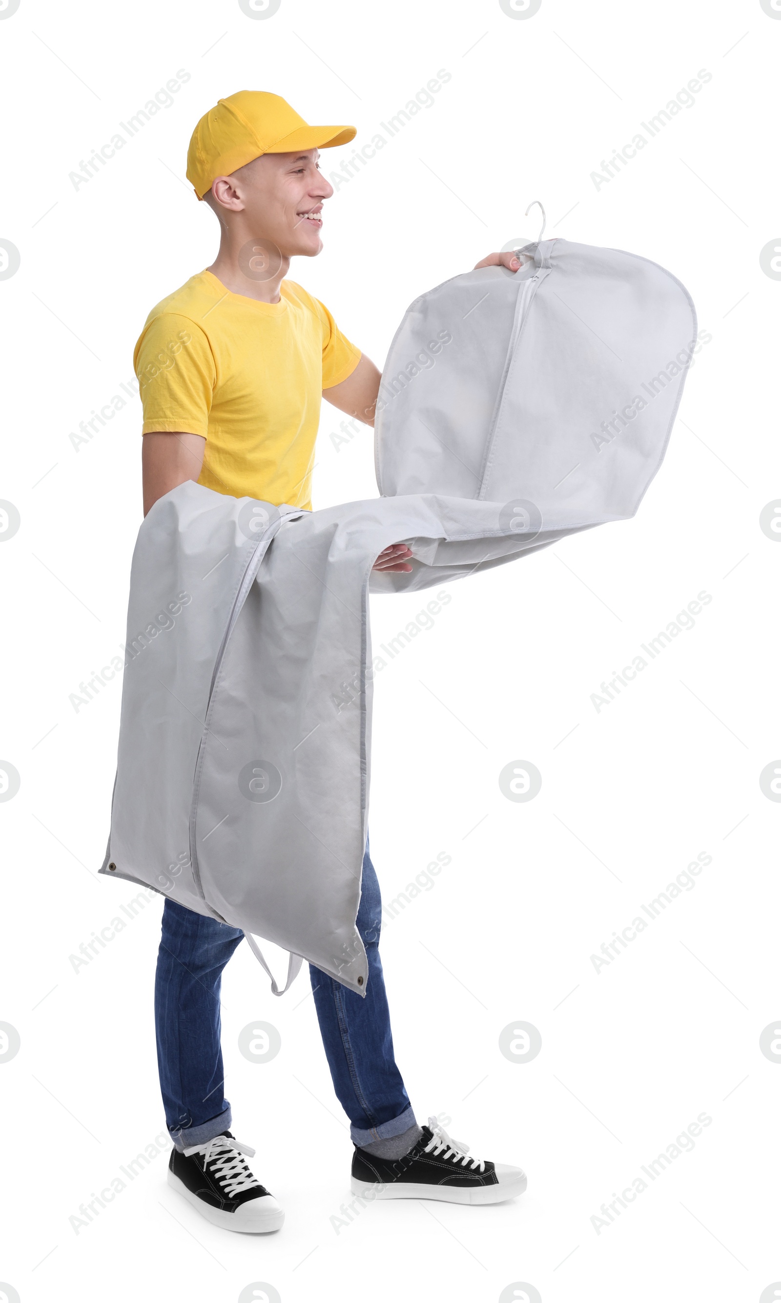 Photo of Dry-cleaning delivery. Happy courier holding garment cover with clothes on white background