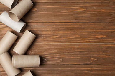 Photo of Flat lay composition with empty toilet paper rolls and space for text on wooden background