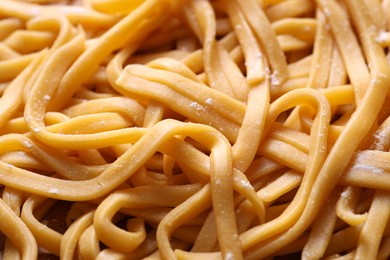 Raw homemade pasta as background, closeup view