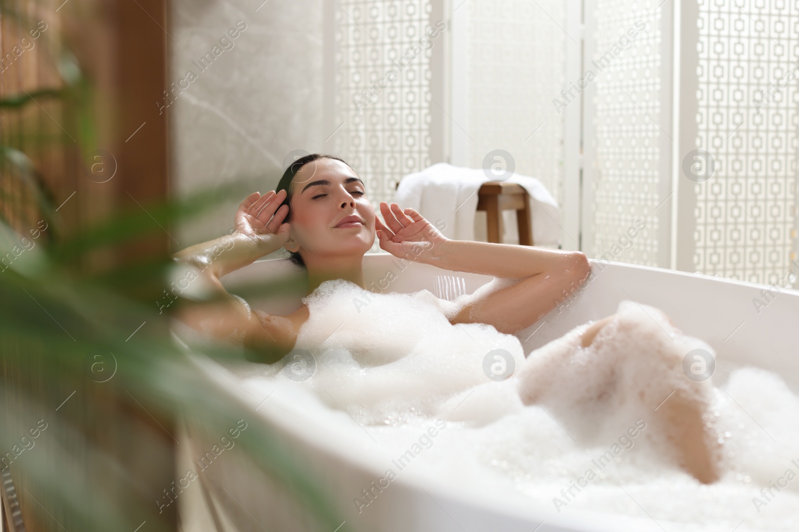 Photo of Beautiful young woman taking bubble bath at home