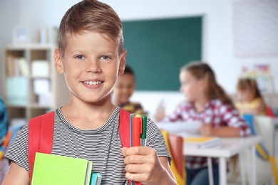 Image of Happy boy with backpack in school classroom