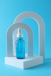 Photo of Stylish presentation of serum on light blue background