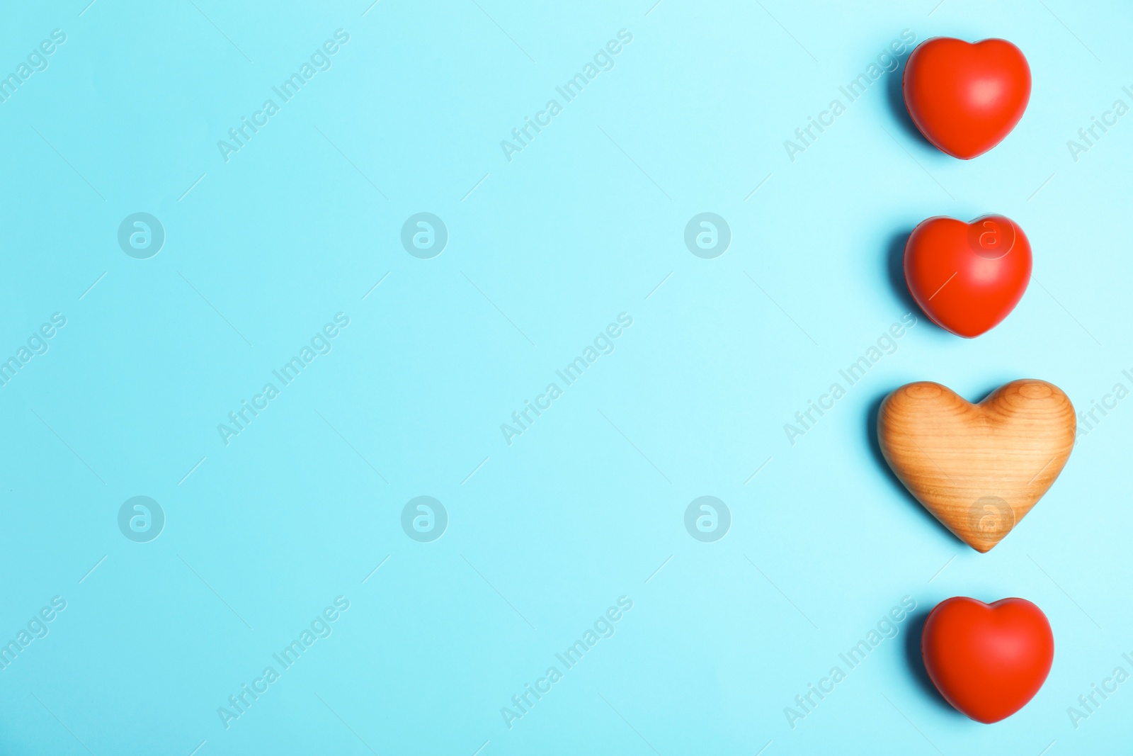 Photo of One different heart among others and space for text on color background, top view. Space for text