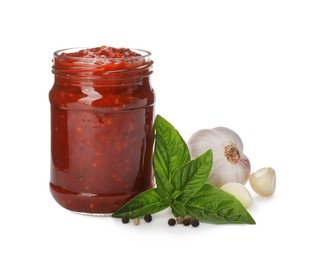 Delicious adjika sauce in glass jar and ingredients isolated on white