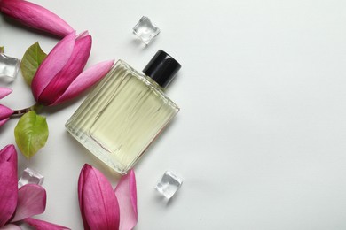 Photo of Beautiful pink magnolia flowers, bottle of perfume and ice cubes on light grey background, flat lay. Space for text