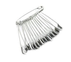 Colorful safety pins on white background, top view