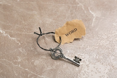 Photo of Vintage key with tag on grey table. Keyword concept