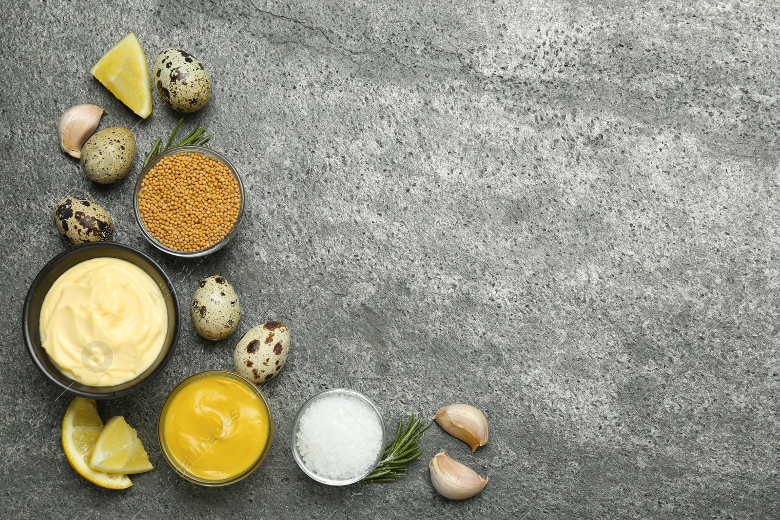 Photo of Delicious homemade mayonnaise, spices and ingredients on grey table, flat lay. Space for text