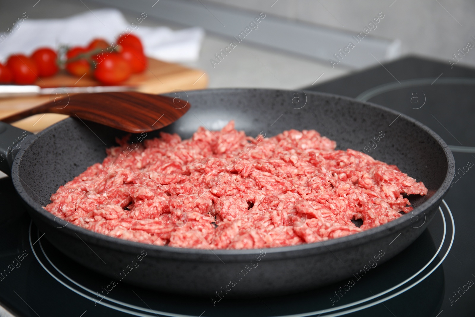 Photo of Frying pan with raw minced meat on induction stove, closeup