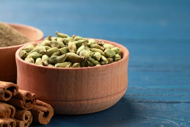Photo of Cardamom and other spices on blue wooden table. Space for text