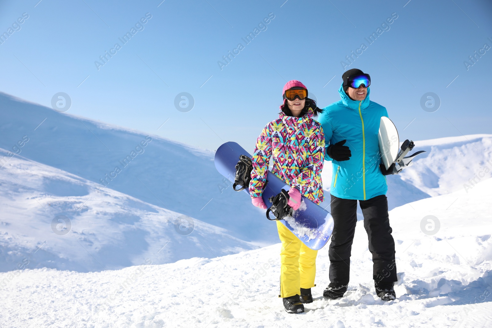 Photo of Couple with snowboards on hill, space for text. Winter vacation