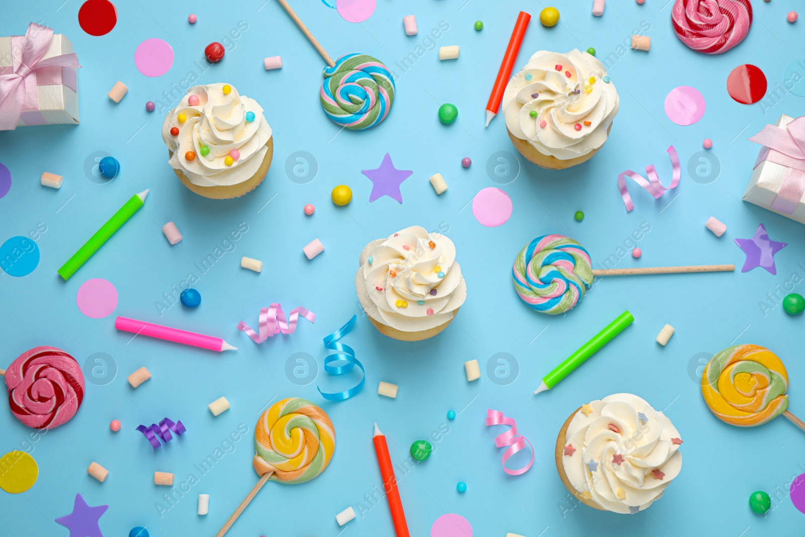 Photo of Flat lay composition with cupcakes on light blue background. Birthday party