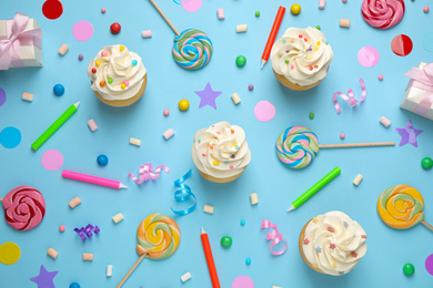 Photo of Flat lay composition with cupcakes on light blue background. Birthday party