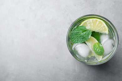 Photo of Glass of fresh Mojito cocktail on grey table, top view. Space for text