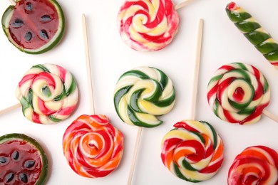 Photo of Many colorful lollipops on white background, flat lay