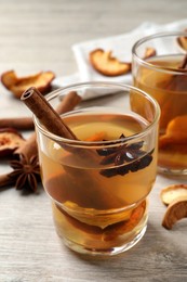 Delicious compote with dried apple slices, anise and cinnamon on white wooden table