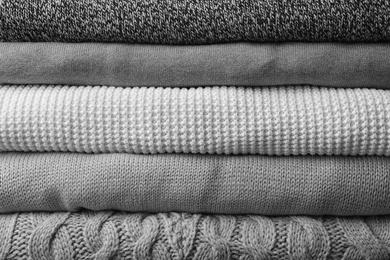 Photo of Stack of warm clothes as background, closeup. Autumn season