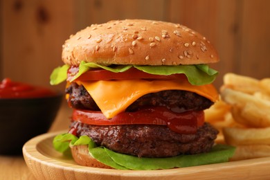 Photo of Tasty cheeseburger with patties, sauce and French fries on wooden table, closeup