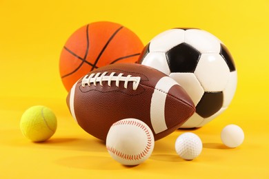Photo of Many different sports balls on yellow background