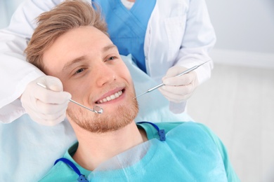 Photo of Dentist examining patient's teeth in modern clinic