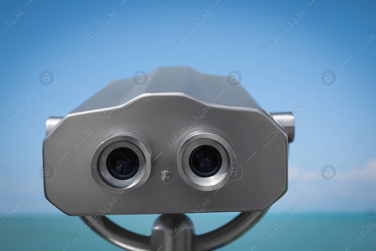 Photo of Metal tower viewer installed near sea, closeup. Mounted binoculars