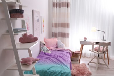 Photo of Comfortable bed with pink linens in children's room