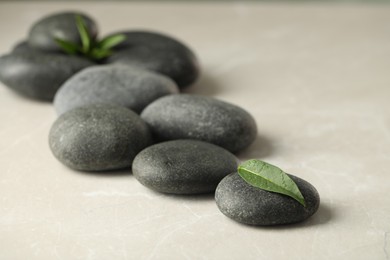 Photo of Spa stones and green leaves on light table