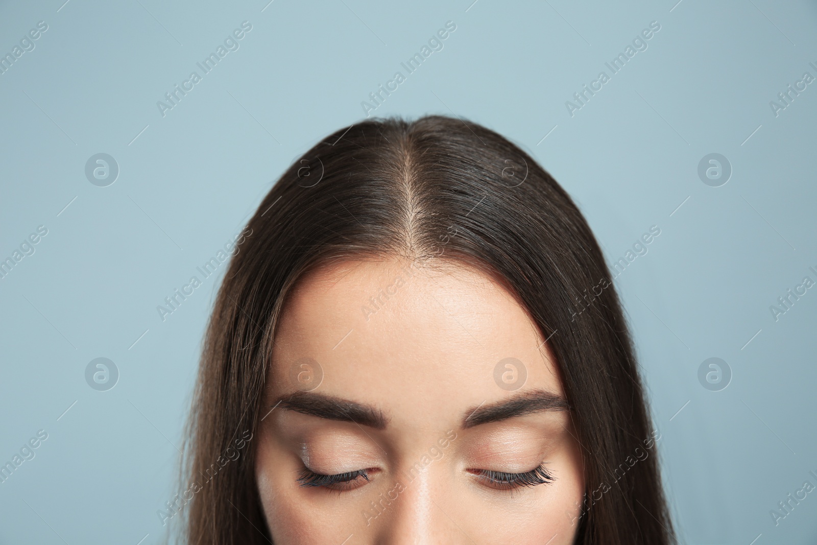 Photo of Woman with hair loss problem on grey background, closeup. Trichology treatment