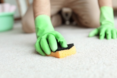 Man cleaning carpet at home