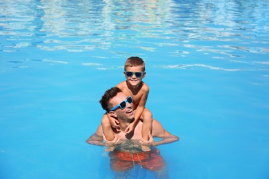 Photo of Little boy with father in swimming pool