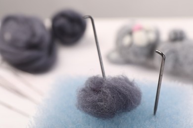 Photo of Felting tools and wool on table, closeup