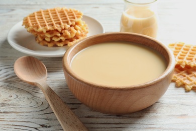 Photo of Bowl with condensed milk served on table, closeup. Dairy products