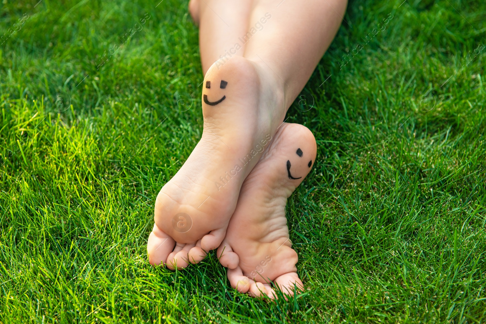 Photo of Teenage girl with smiling faces drawn on heels outdoors, closeup