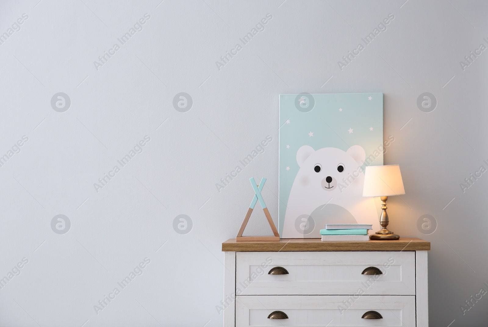 Photo of Modern white chest of drawers near light wall in child room, space for text. Interior design