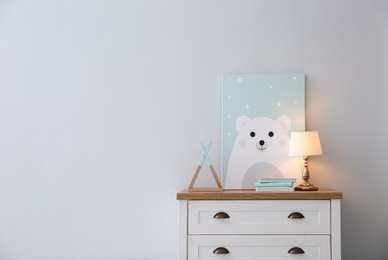 Photo of Modern white chest of drawers near light wall in child room, space for text. Interior design