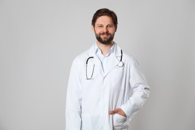 Photo of Doctor or medical assistant (male nurse) with stethoscope on light grey background