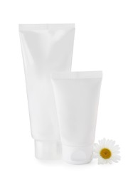 Photo of Tubes of hand cream and chamomile on white background